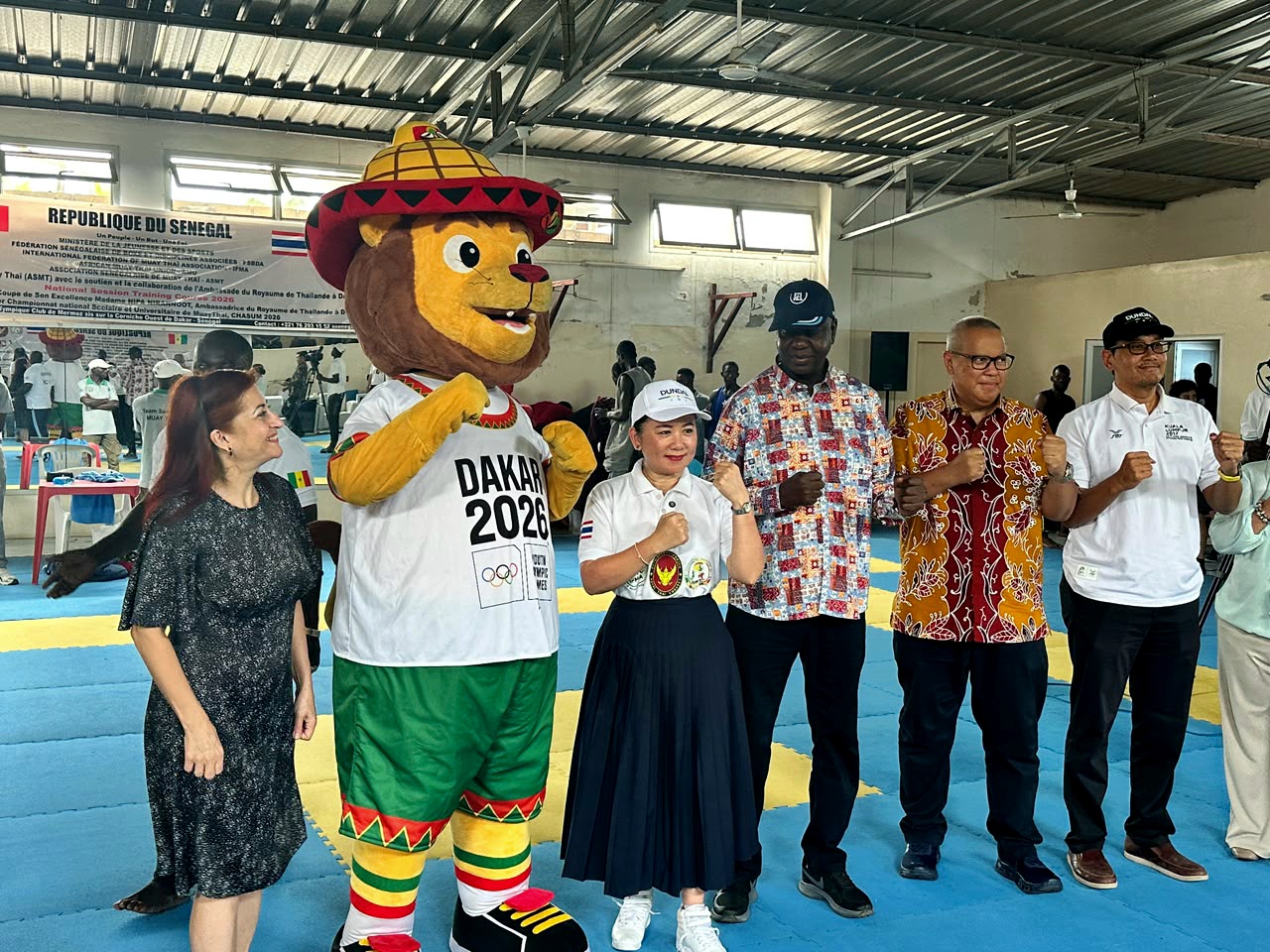L’Ambassadrice de Thaïlande au Sénégal et des responsables du Muay Thaï posent avec la mascotte Dakar 2026 lors de la Coupe de l’Ambassade à Dakar.