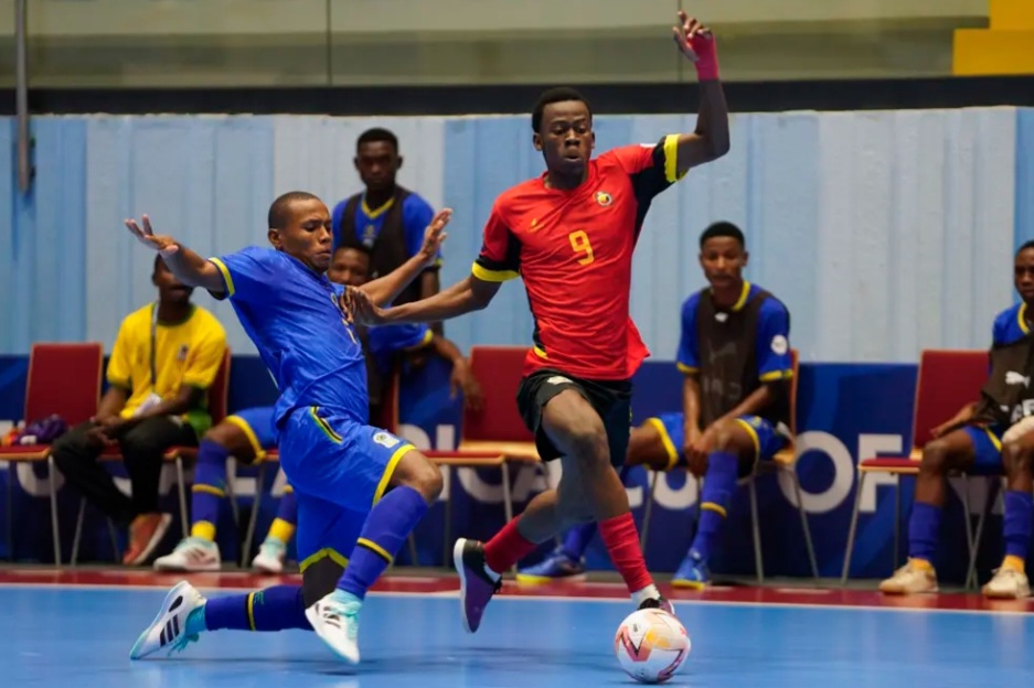 Joueur du Mozambique en maillot rouge numéro 9 face à un joueur de la Tanzanie en maillot bleu lors de la CAN de futsal.